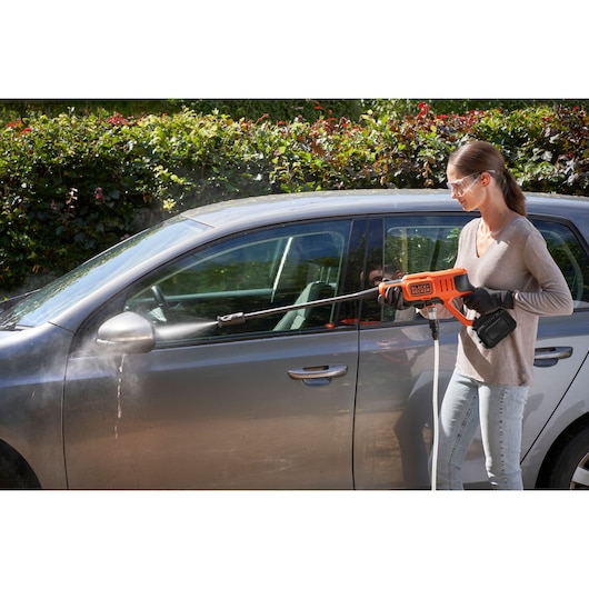 BLACKDECKER BCPC20D1 portable pressure washer used to clean a car outdoors.