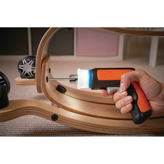 BLACK+DECKER BCRTA601I cordless screwdriver with orange and black handle, used to assemble wooden furniture.