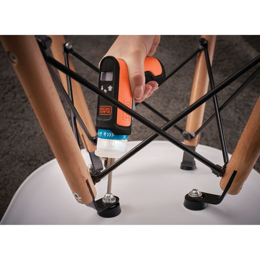 Photo of BLACKDECKER BCRTA601I electric screwdriver tightening a chair leg bolt, close-up view.