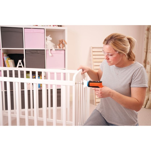 BLACKDECKER BCRTA601I cordless screwdriver used to assemble a white baby crib in a nursery.
