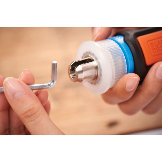 BLACKDECKER BCRTA601I photography of drill chuck adjustment with hex key held by hands.