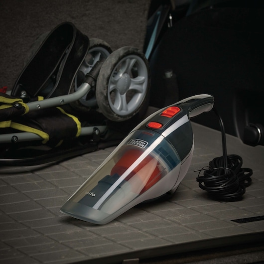 Photo of BLACKDECKER handheld vacuum cleaner BDCV370-LA with cord, on a car floor near a folded stroller.
