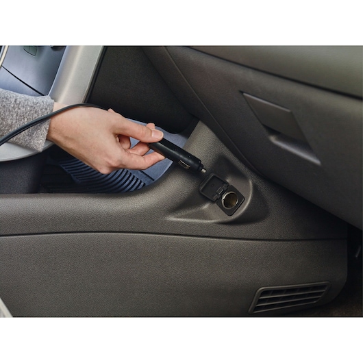 BLACKDECKER BDINF12C car inflator power cord being plugged into vehicle 12V outlet, close-up view.