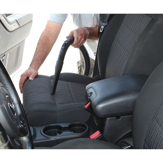 BLACKDECKER BDWD10 car vacuum cleaner used on car seat upholstery, close-up angle.