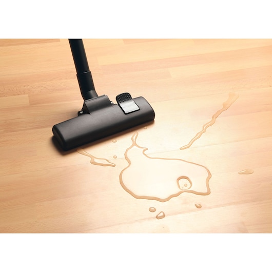 BLACKDECKER BDWD20 vacuum cleaner head on wood floor cleaning liquid spill, top view.