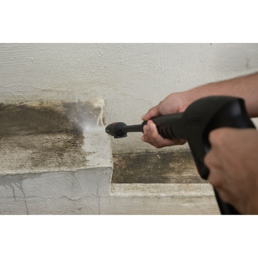 BLACKDECKER BEPW1520 pressure washer cleaning dirt from a concrete step, close-up outdoor use.