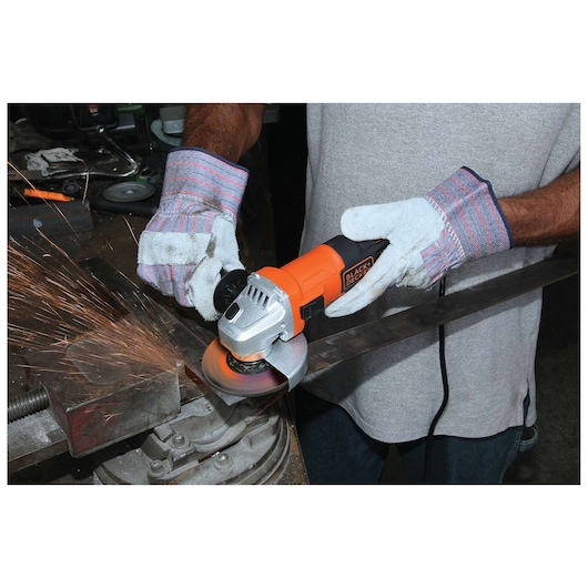 Photo of BLACKDECKER G650 angle grinder in use, orange and black, emitting sparks while grinding metal.