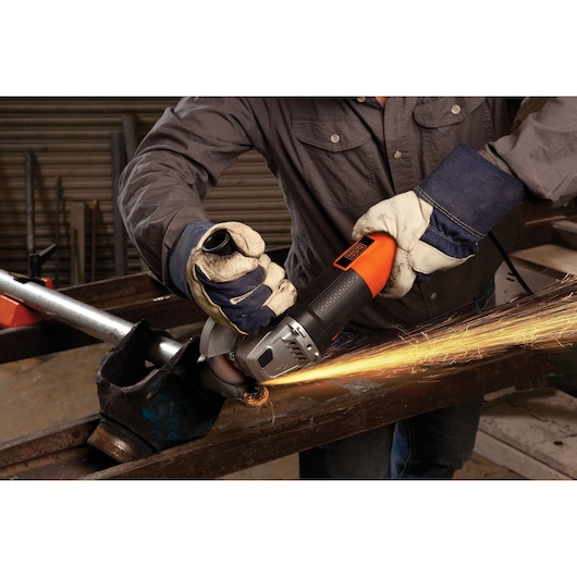 BLACKDECKER G720 angle grinder being used on metal, sparks flying, worker wearing gloves and protective clothing.