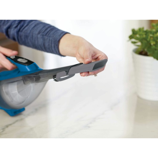 BLACKDECKER HLVA320J26 handheld vacuum being used with a crevice tool attachment on a countertop.