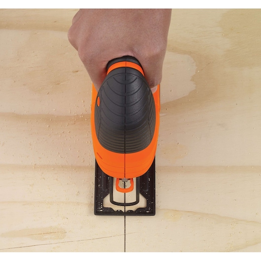 Photo of BLACKDECKER KS701PEK jigsaw cutting a straight line in wood, top view close-up.