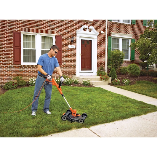 BLACKDECKER MTE912 lawn mower and trimmer in use on a residential lawn, orange and black design.