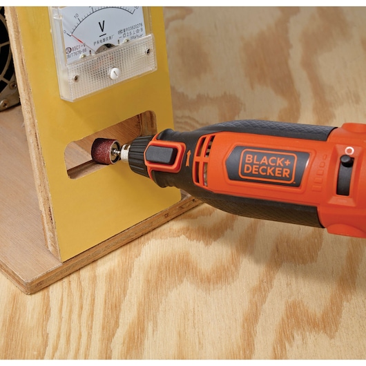 BLACKDECKER RT18KA rotary tool sanding wood, close-up side angle.
