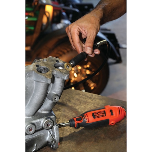 BLACKDECKER RT18KA rotary tool being used to grind metal part in workshop setting.